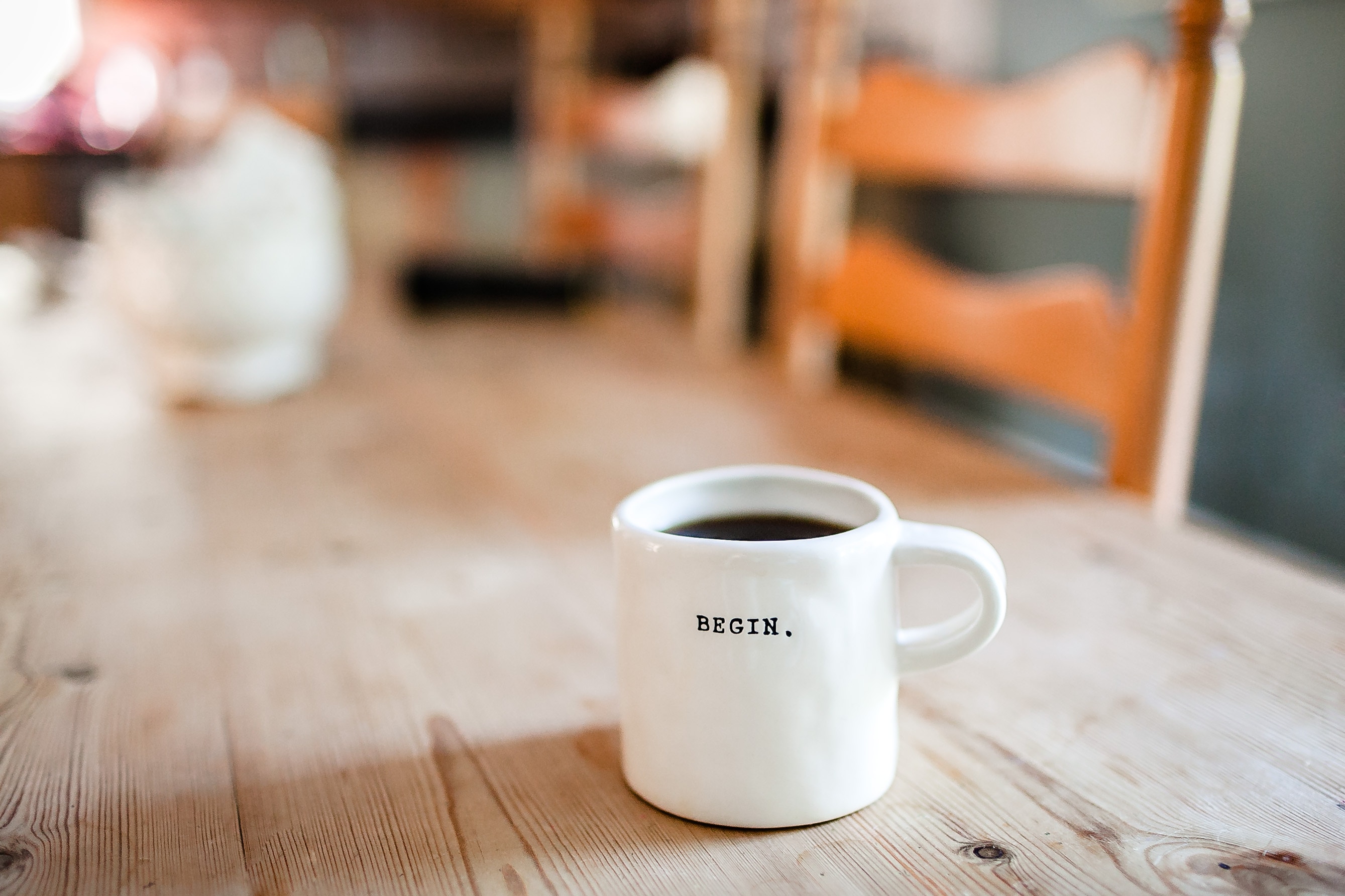 Coffee cup on table that says "begin"