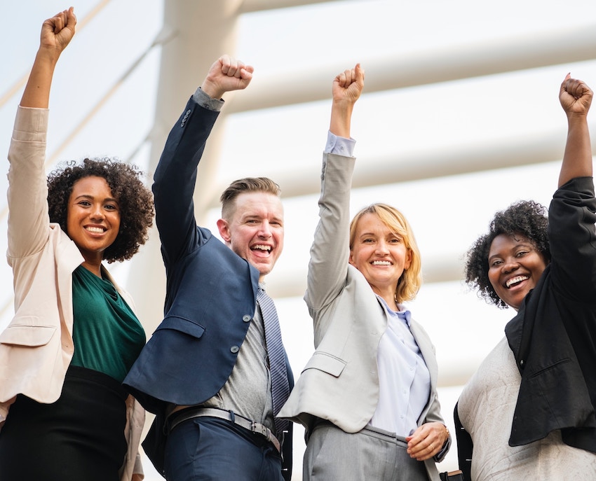 group of happy people with their fists in the air