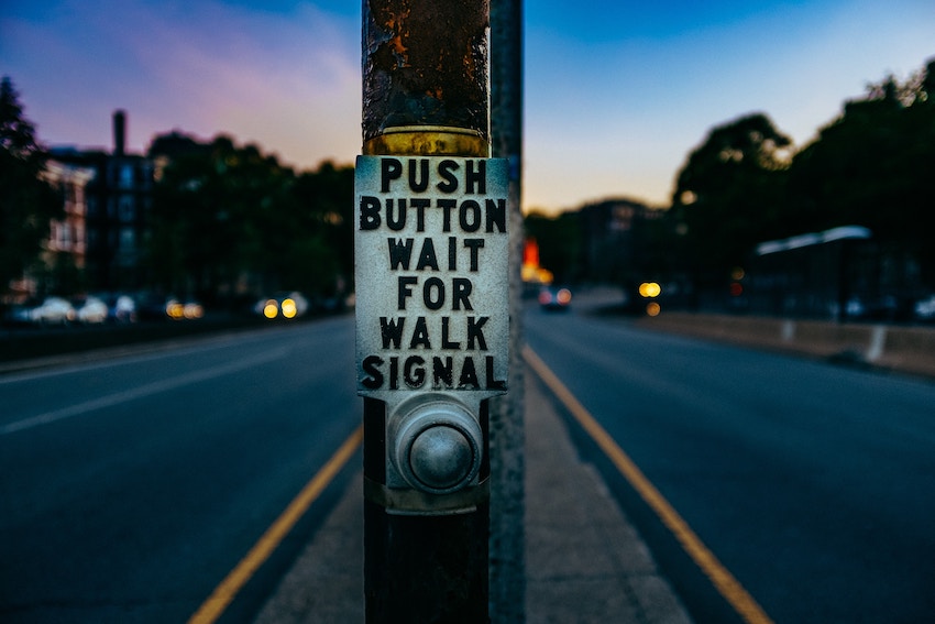 crosswalk sign that says press button for walk signal