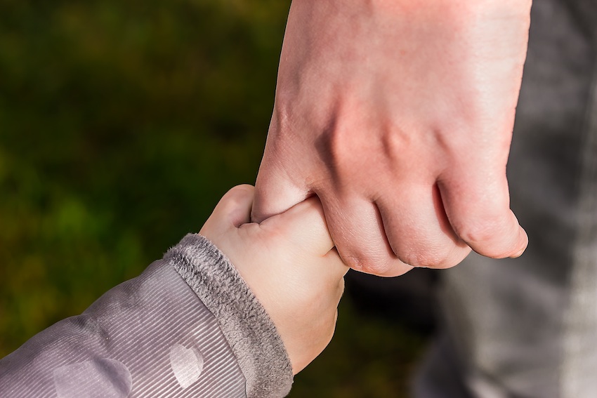 father and baby holding hands