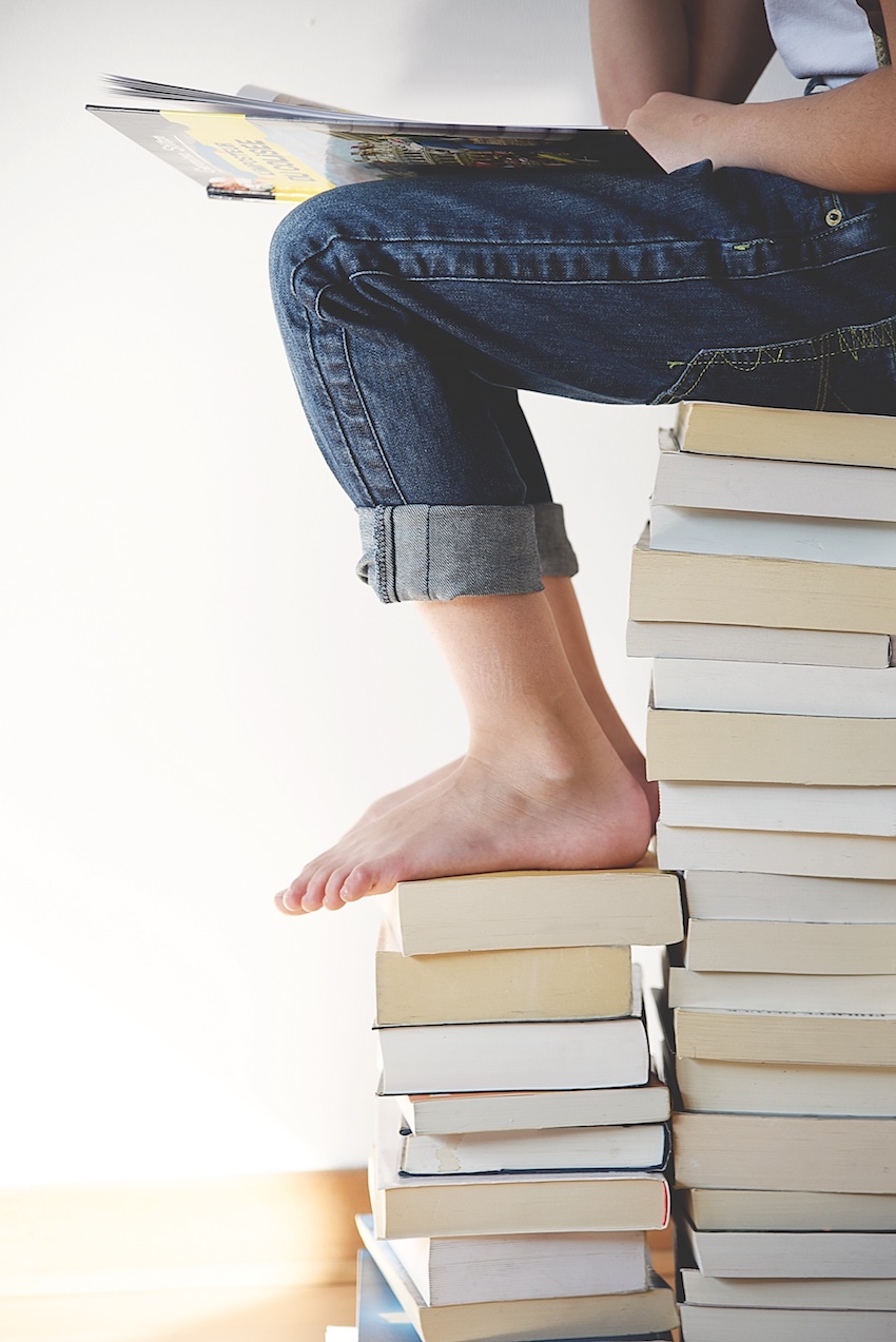 person reading on stack of books