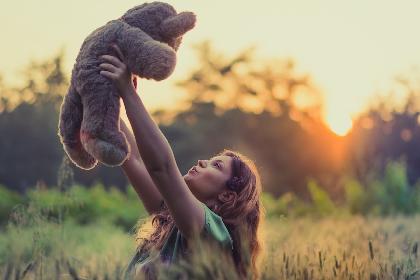 girl holding up teddy bear