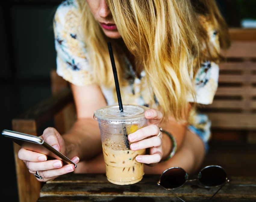 girl holding coffee and smartphone