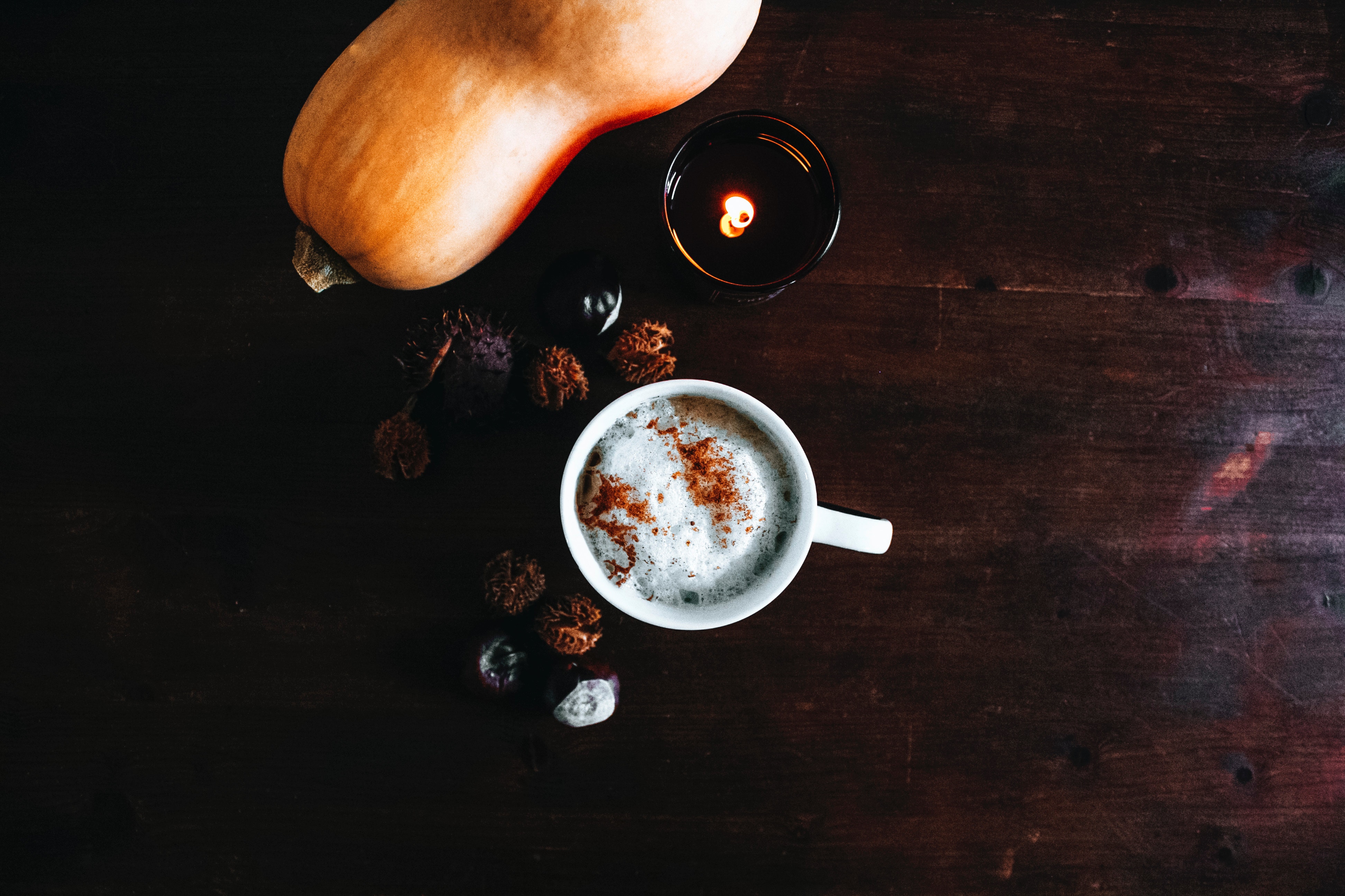 photo of a table with a pumpkin spice latte and a gourd