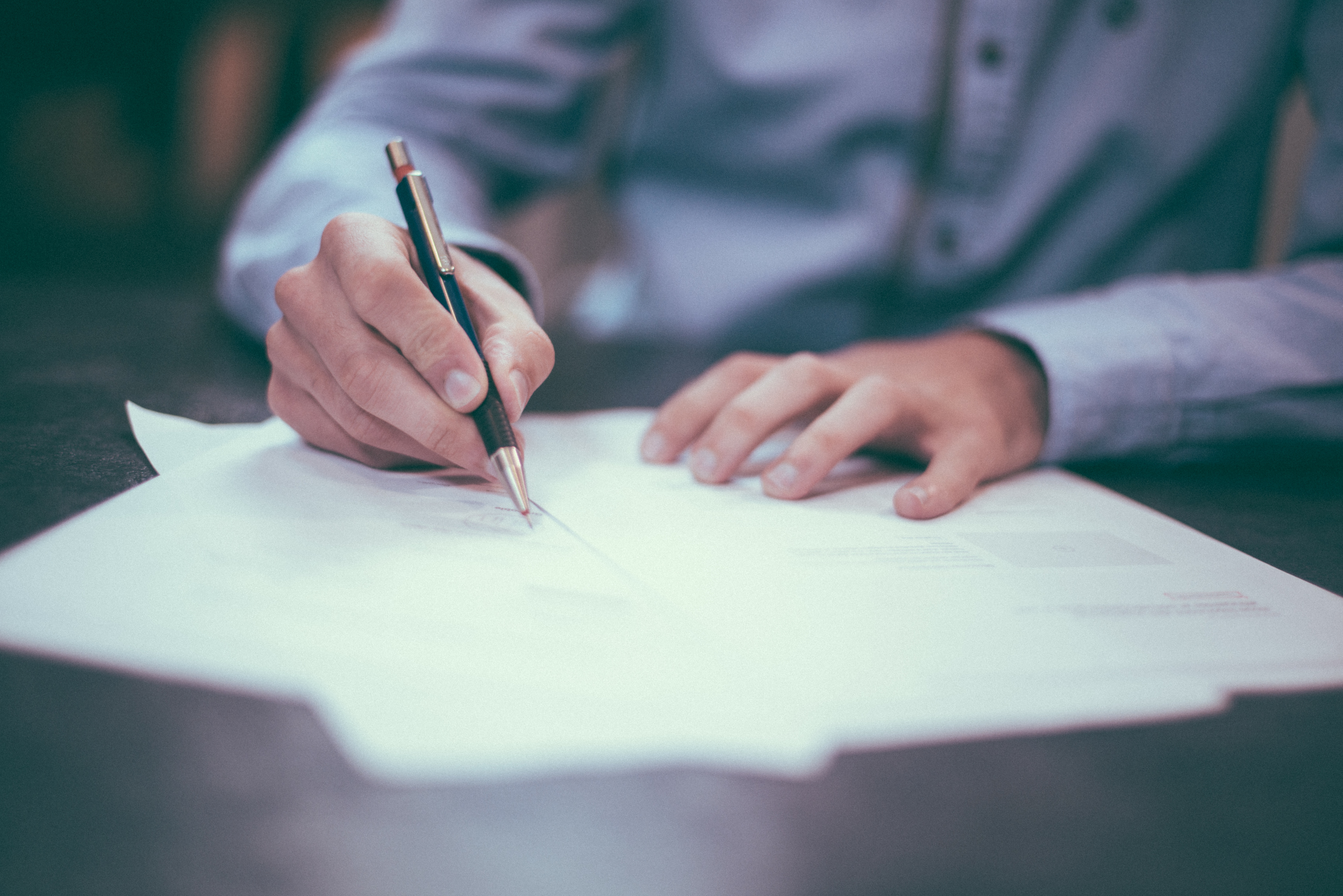 man signing document in pen