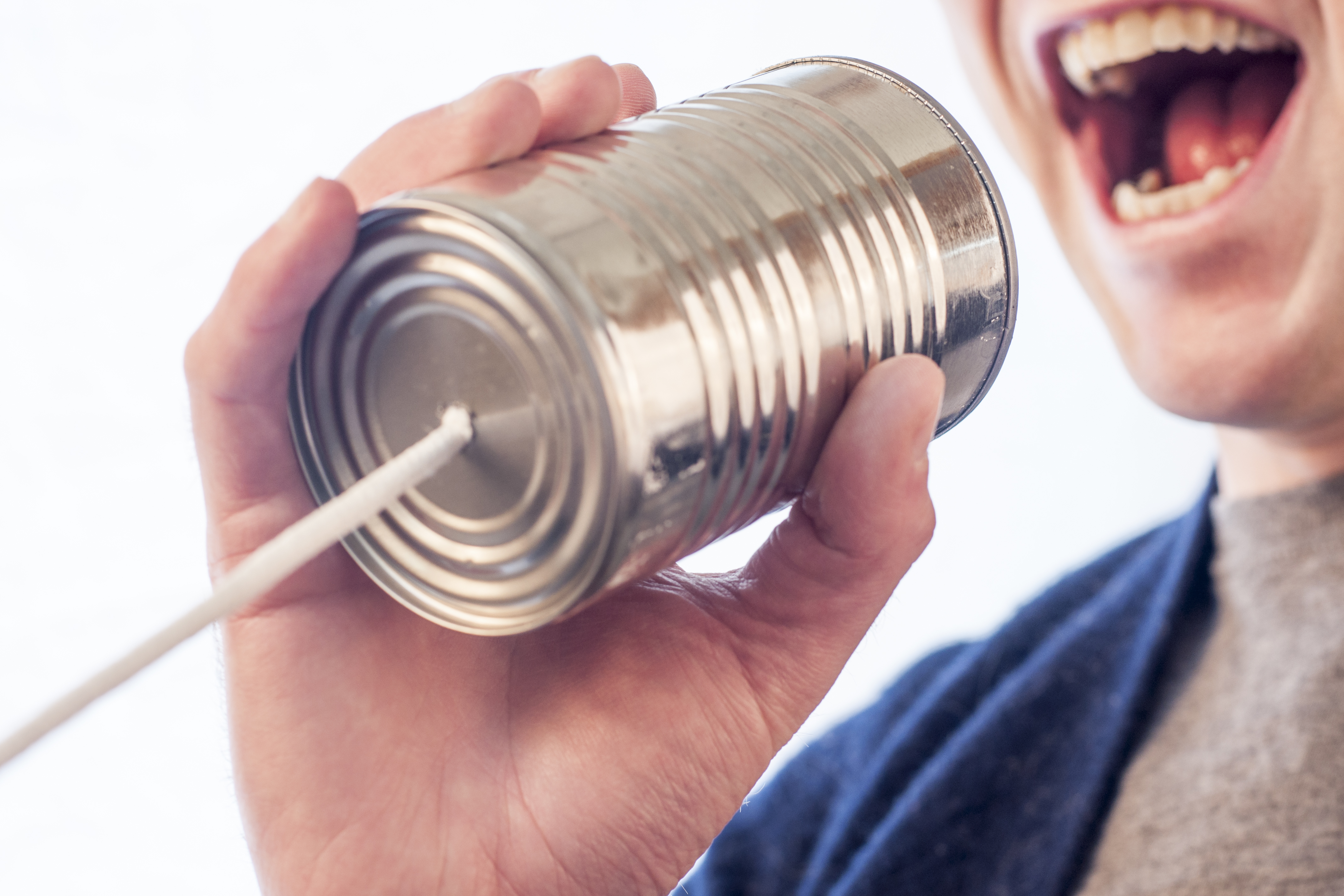 woman holding tin can with string to mouth