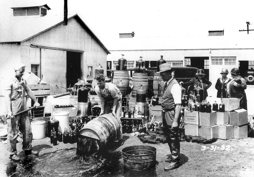 people dumping out alcohol barrels during the Prohibition era