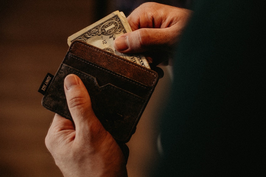 person taking cash out of wallet