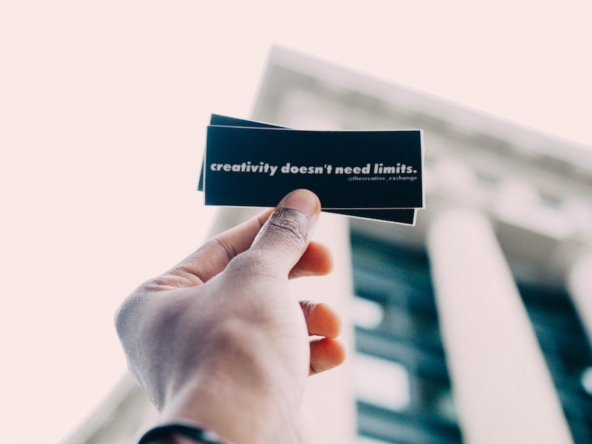 man holding note that says creativity doesnt need limits