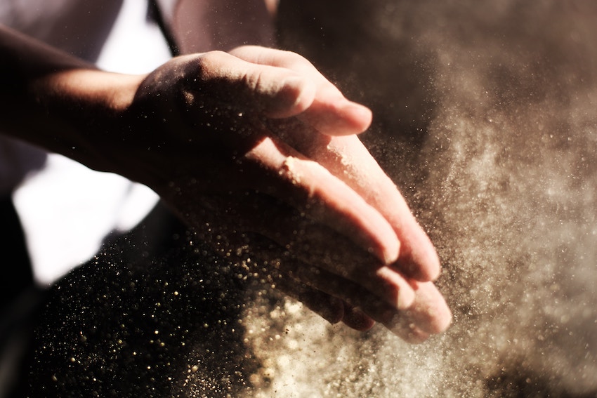 person clapping floured hands together