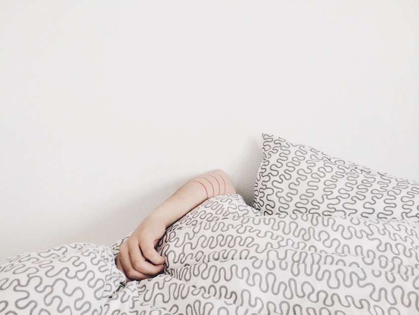 kid hiding under blanket