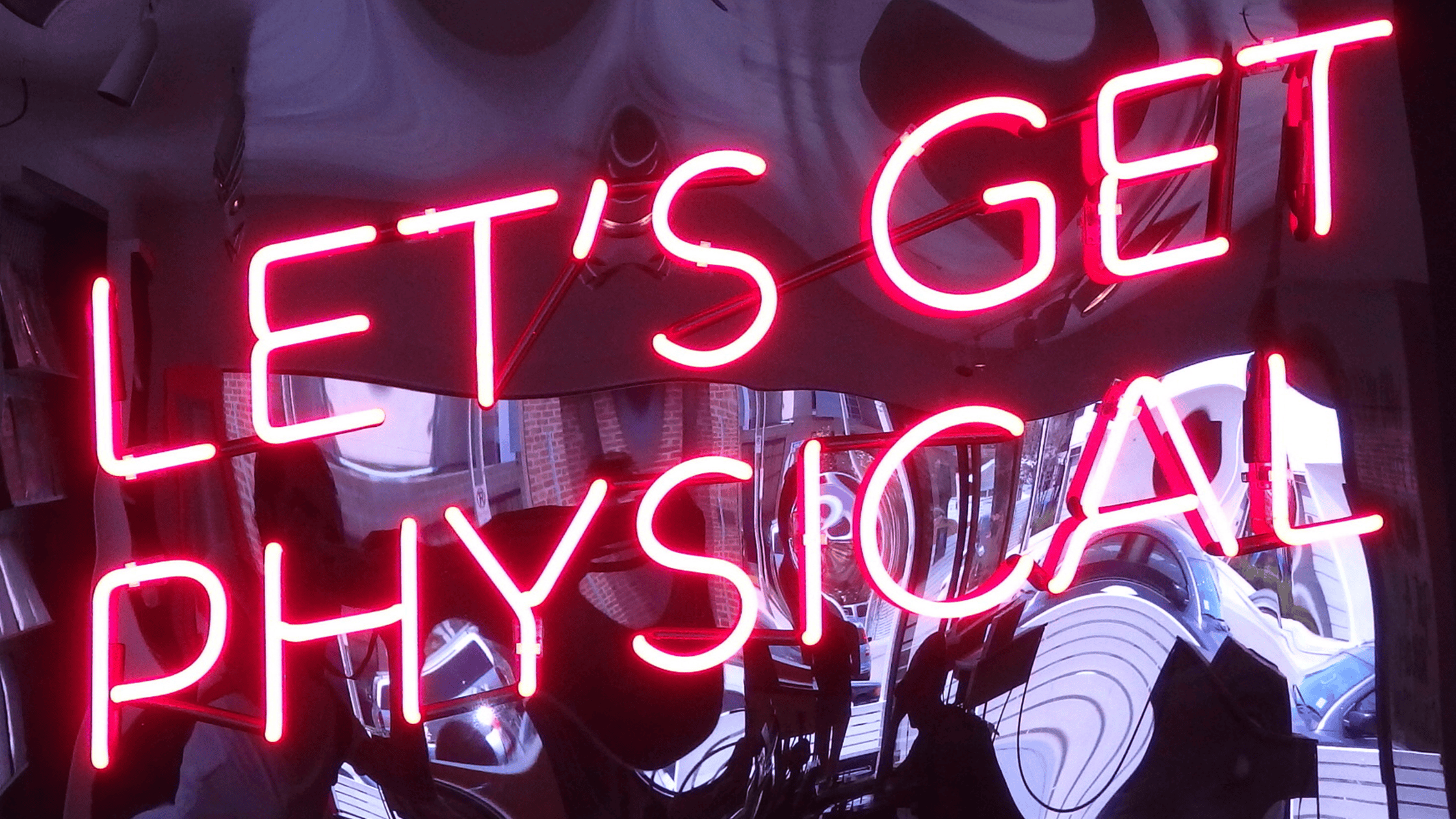 a neon sign that says "let's get physical"